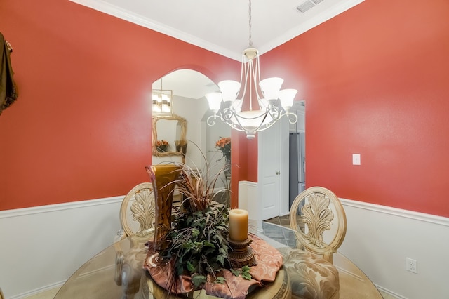 dining area featuring ornamental molding and an inviting chandelier