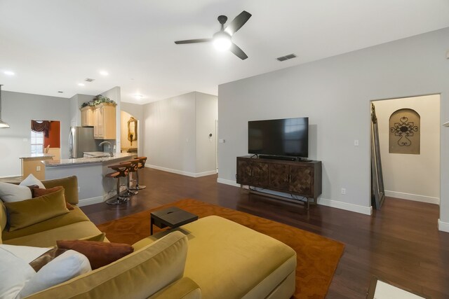 living room featuring ceiling fan, dark hardwood / wood-style flooring, and sink