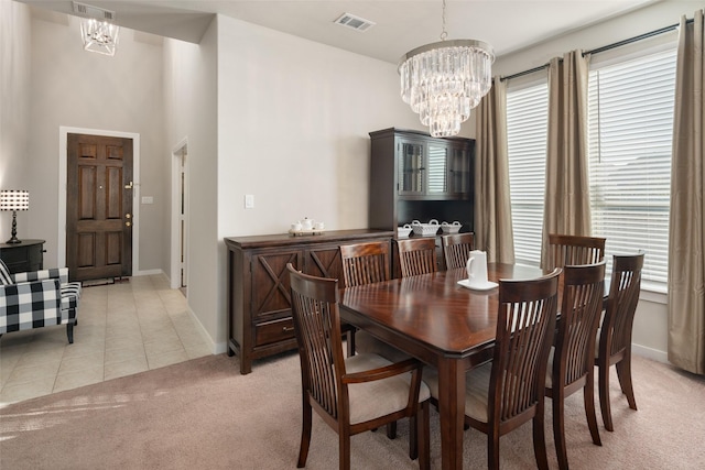 carpeted dining room with an inviting chandelier