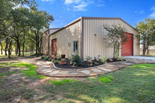 view of outdoor structure featuring a garage and a lawn