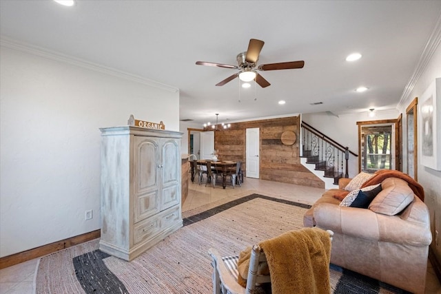 tiled living room featuring ornamental molding and ceiling fan with notable chandelier