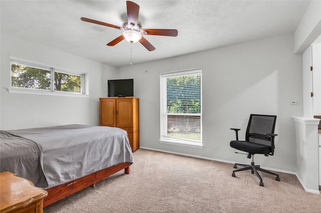 bedroom with light carpet, multiple windows, and ceiling fan