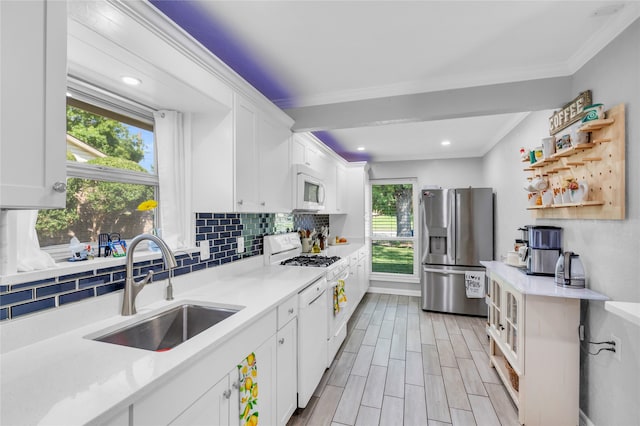 kitchen featuring white cabinets, light hardwood / wood-style flooring, sink, and white appliances