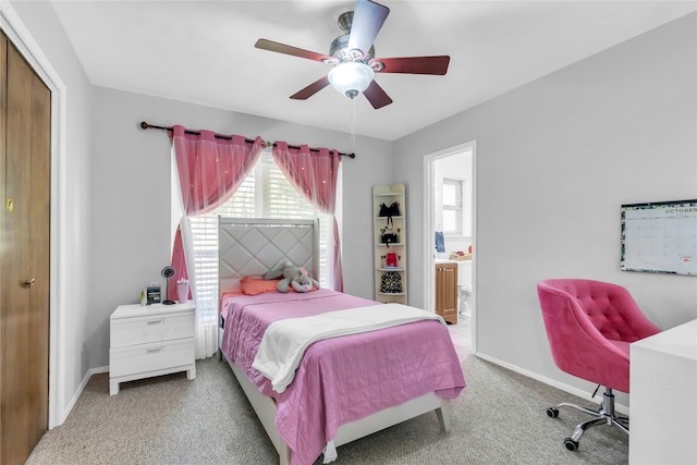 bedroom featuring light carpet, ceiling fan, ensuite bathroom, and a closet