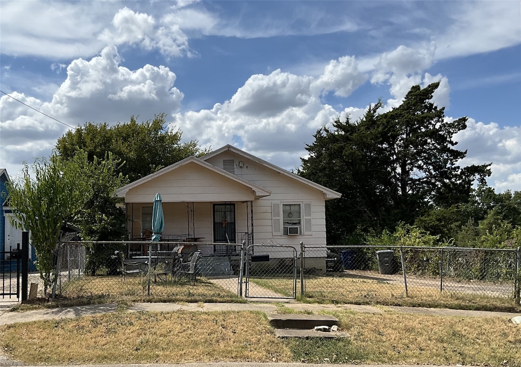 view of front of house featuring a front lawn, cooling unit, and a porch