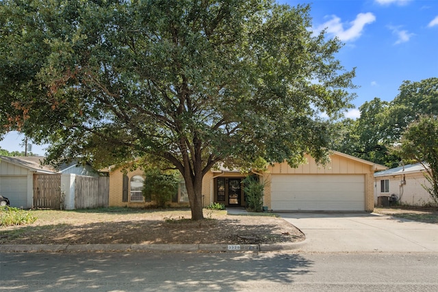 view of property hidden behind natural elements with a garage