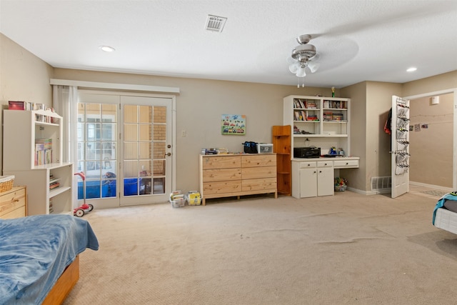 carpeted bedroom featuring access to outside, a textured ceiling, and ceiling fan