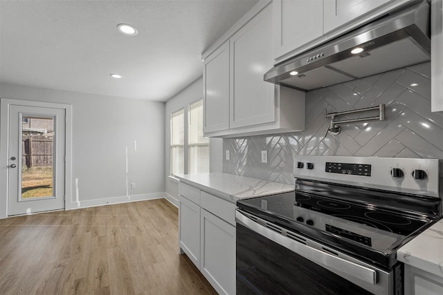 kitchen with white cabinetry, light hardwood / wood-style flooring, exhaust hood, and stainless steel range with electric cooktop