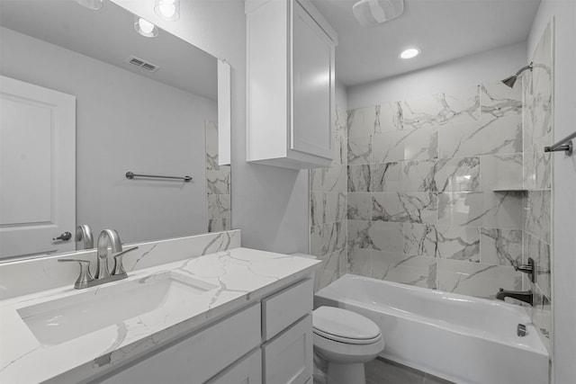 full bathroom featuring vanity, tiled shower / bath combo, and toilet