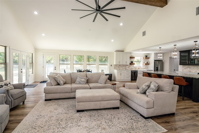 living room featuring wood-type flooring, french doors, and high vaulted ceiling