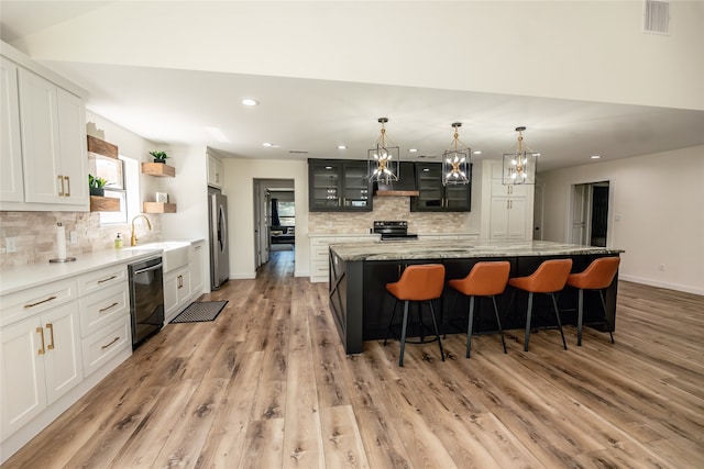 kitchen featuring light hardwood / wood-style floors, appliances with stainless steel finishes, sink, and a center island