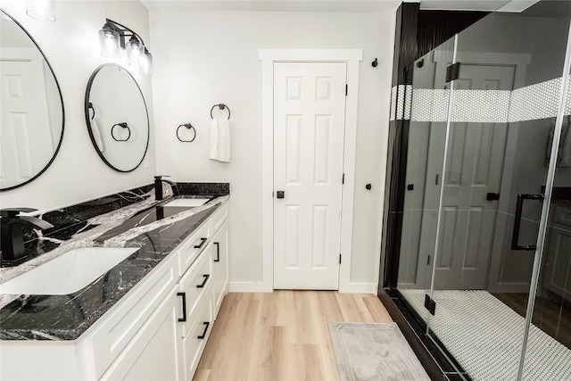 bathroom featuring walk in shower, hardwood / wood-style flooring, and vanity