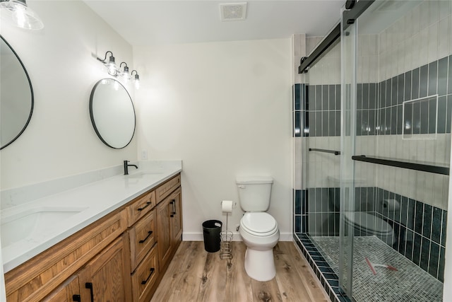 bathroom featuring an enclosed shower, vanity, toilet, and wood-type flooring