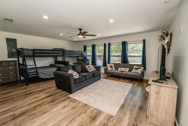 bedroom with wood-type flooring, electric panel, and ceiling fan