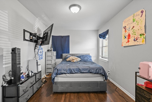 bedroom featuring baseboards and wood finished floors