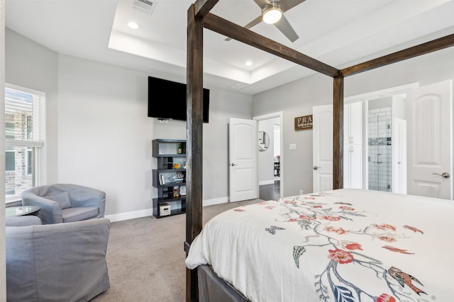 carpeted bedroom featuring ceiling fan and a raised ceiling