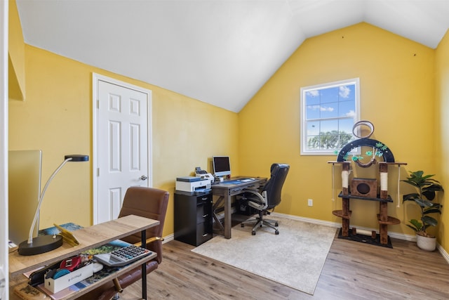 office with light wood-type flooring and vaulted ceiling