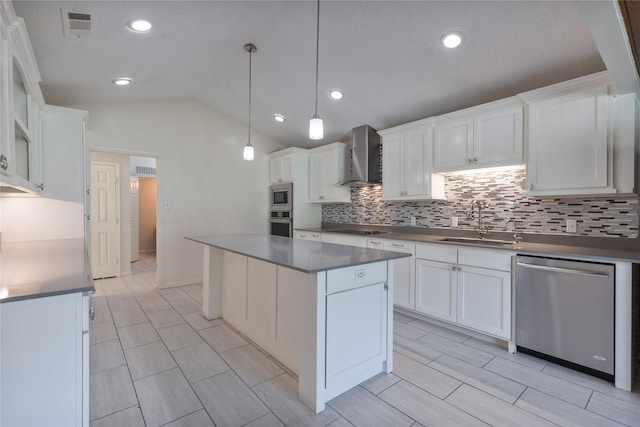 kitchen with stainless steel appliances, dark countertops, white cabinetry, a sink, and wall chimney exhaust hood