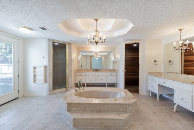 bathroom with tile patterned floors, separate shower and tub, vanity, a chandelier, and a textured ceiling