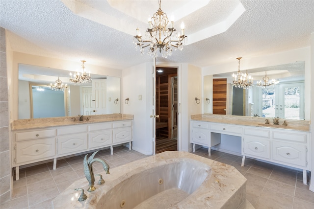 bathroom with vanity, a textured ceiling, a tub, and tile patterned floors