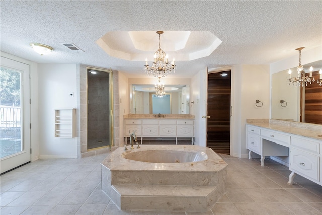 bathroom featuring visible vents, a raised ceiling, a textured ceiling, vanity, and a chandelier