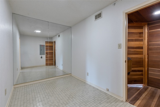 empty room featuring electric panel and light wood-type flooring