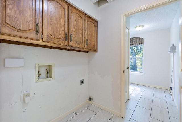 clothes washing area featuring cabinets, a textured ceiling, washer hookup, and electric dryer hookup