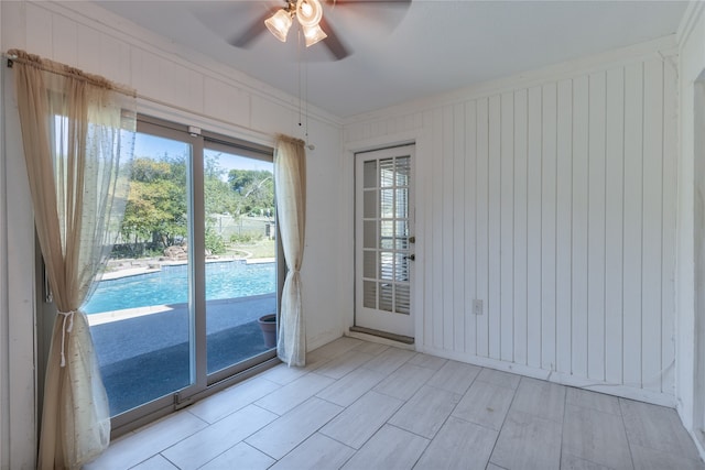 entryway featuring ceiling fan and crown molding