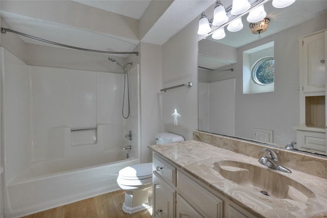 bathroom featuring toilet, shower / washtub combination, wood finished floors, and vanity