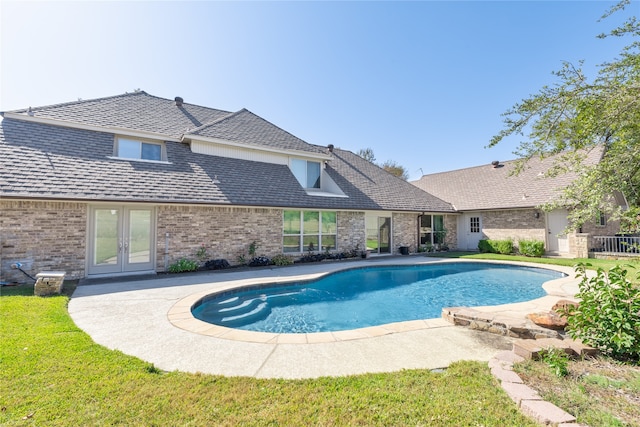 view of swimming pool with a patio area, french doors, and a yard