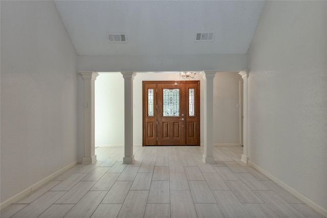 foyer featuring baseboards, visible vents, and ornate columns