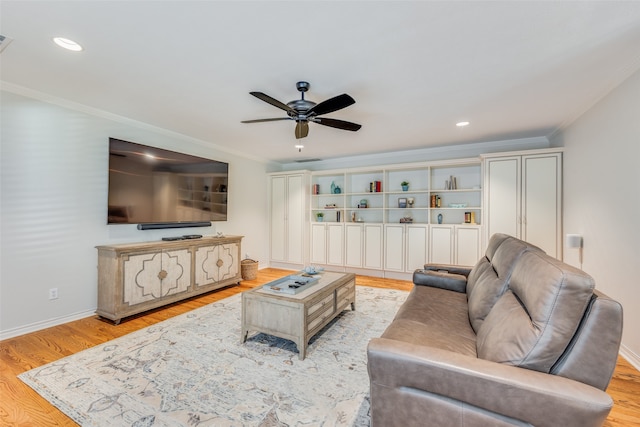 living room with light hardwood / wood-style flooring, ornamental molding, and ceiling fan