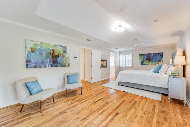 bedroom with crown molding, vaulted ceiling, light wood-type flooring, and ceiling fan