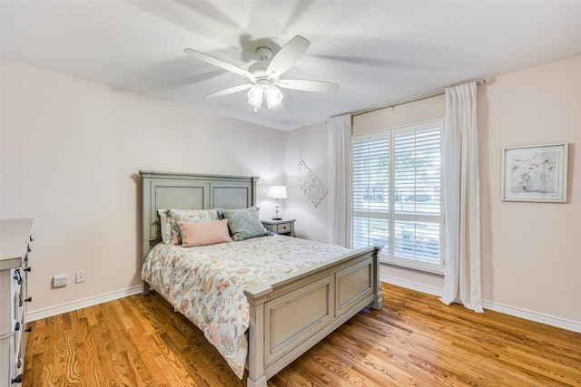 bedroom with light wood finished floors, baseboards, and a ceiling fan