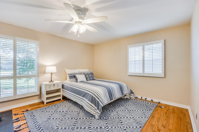 bedroom with baseboards, a ceiling fan, and wood finished floors