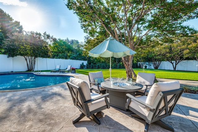 view of pool featuring a patio area, an outdoor fire pit, a fenced backyard, a yard, and a fenced in pool