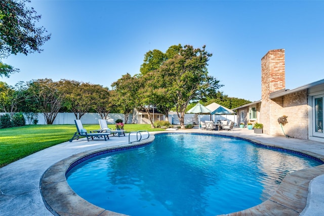 view of swimming pool with a fenced in pool, a lawn, a fenced backyard, and a patio