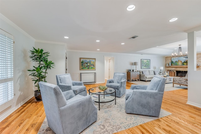 living area with visible vents, crown molding, baseboards, and a notable chandelier