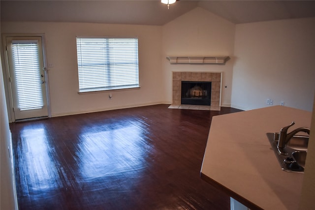 unfurnished living room featuring a fireplace, dark hardwood / wood-style floors, and vaulted ceiling