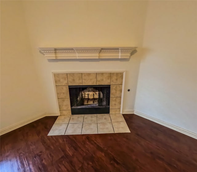 interior details featuring hardwood / wood-style floors and a tiled fireplace