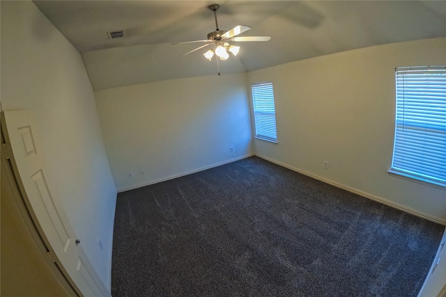 unfurnished room with lofted ceiling, dark colored carpet, and ceiling fan