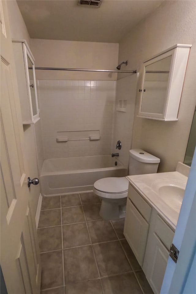 full bathroom with tiled shower / bath, vanity, toilet, and tile patterned floors