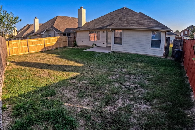 rear view of property featuring a yard and a patio