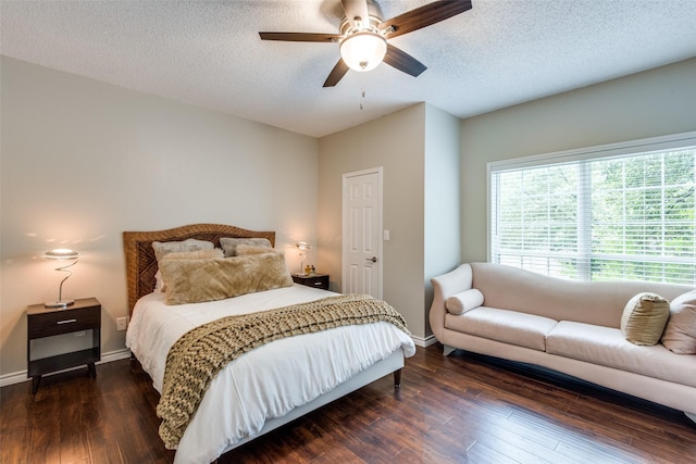 bedroom with a textured ceiling, ceiling fan, and dark hardwood / wood-style floors