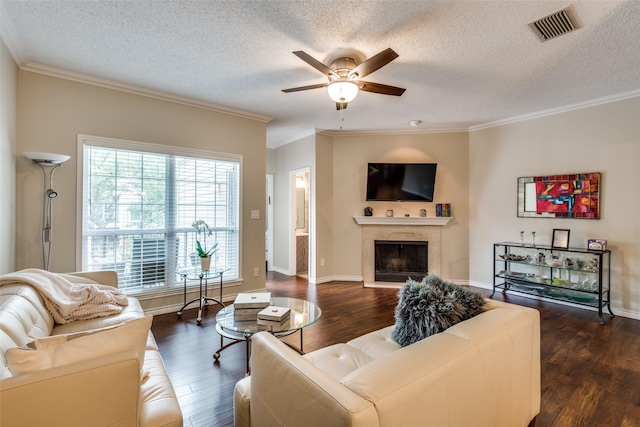 living room with a textured ceiling, dark hardwood / wood-style flooring, crown molding, and ceiling fan