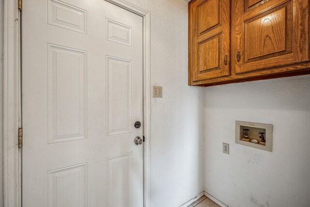 washroom with hookup for a washing machine and cabinets