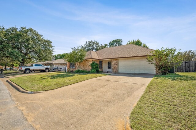 ranch-style house featuring a garage and a front lawn