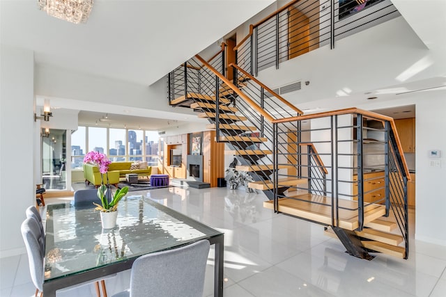 tiled dining space featuring an inviting chandelier and a towering ceiling