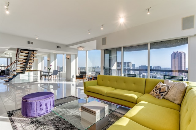 living room featuring expansive windows, track lighting, and a healthy amount of sunlight