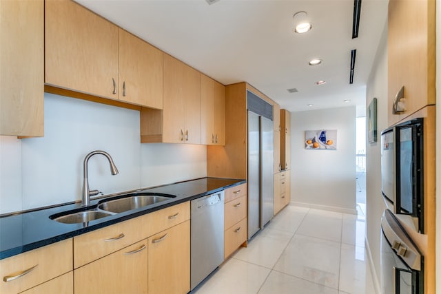 kitchen with appliances with stainless steel finishes, sink, light brown cabinets, and light tile patterned flooring